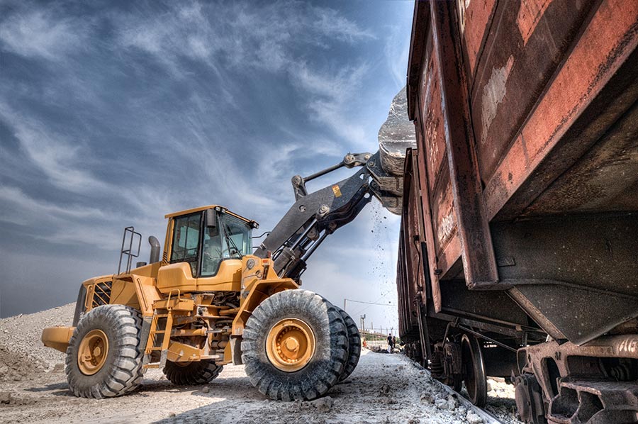 bulldozer-dropping-granite-into-railroad-car